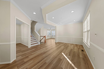 Wood-finish flooring throughout, recessed lighting, crown molding, and wainscoting details
