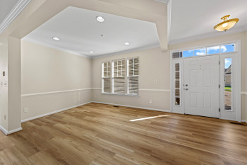 Wood-finish flooring, recessed lighting, crown molding, double front door with sidelights and transom, and multiple windows with blinds