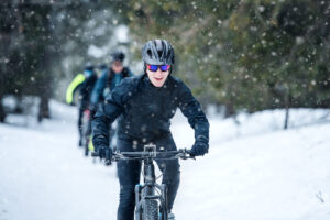 a group of people rides mountain bikes in the winter