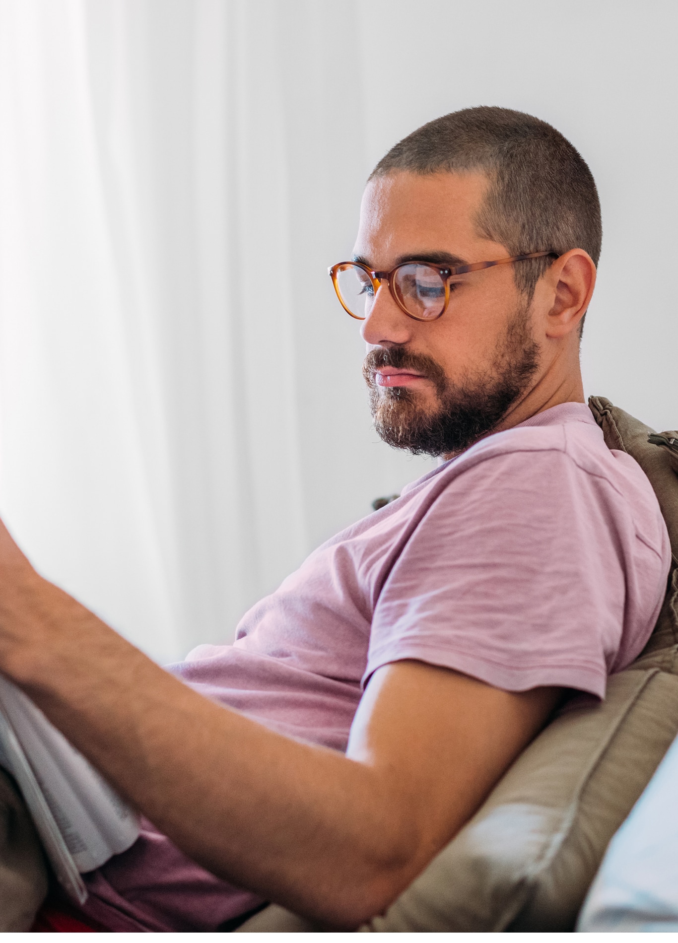 A fine-looking man sitting in the bed, reading newspapers 
