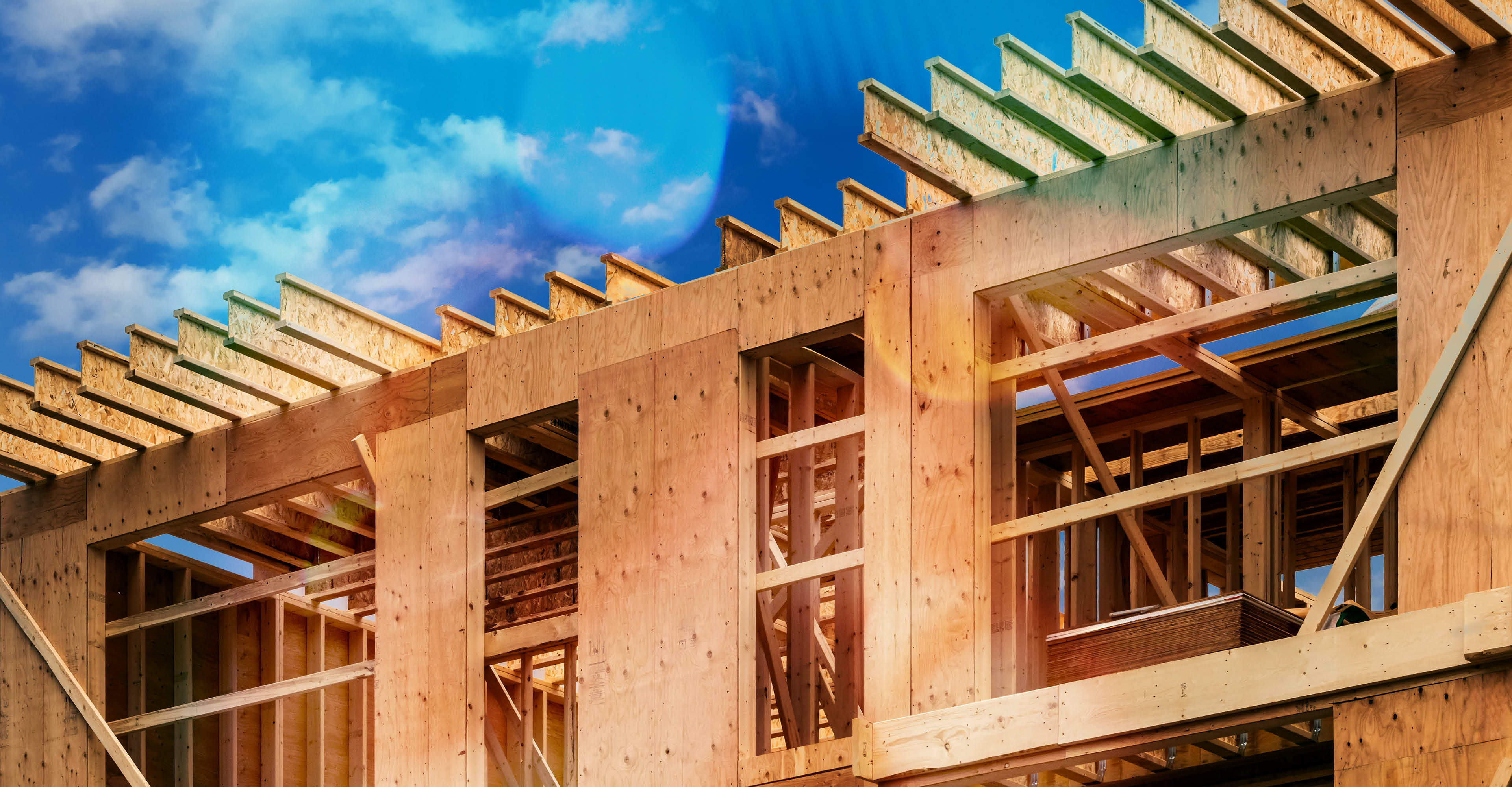 Plywood sheathing and engineered wood joists/rafters forming the roof of a house under construction