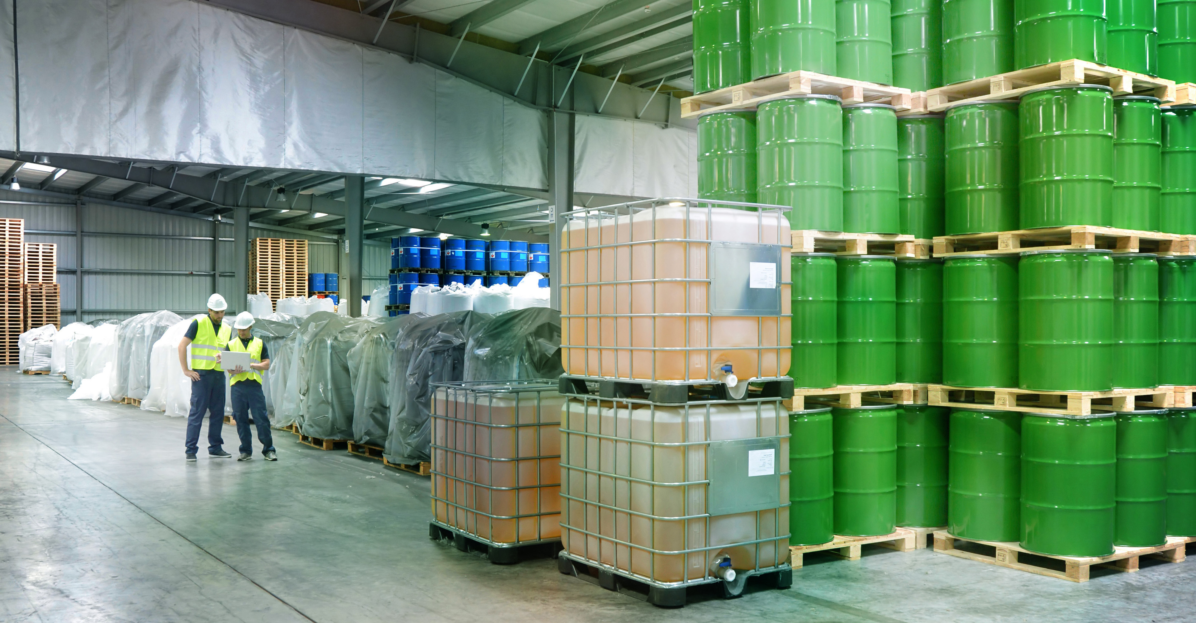 group of workers in the logistics industry work in a warehouse with chemicals