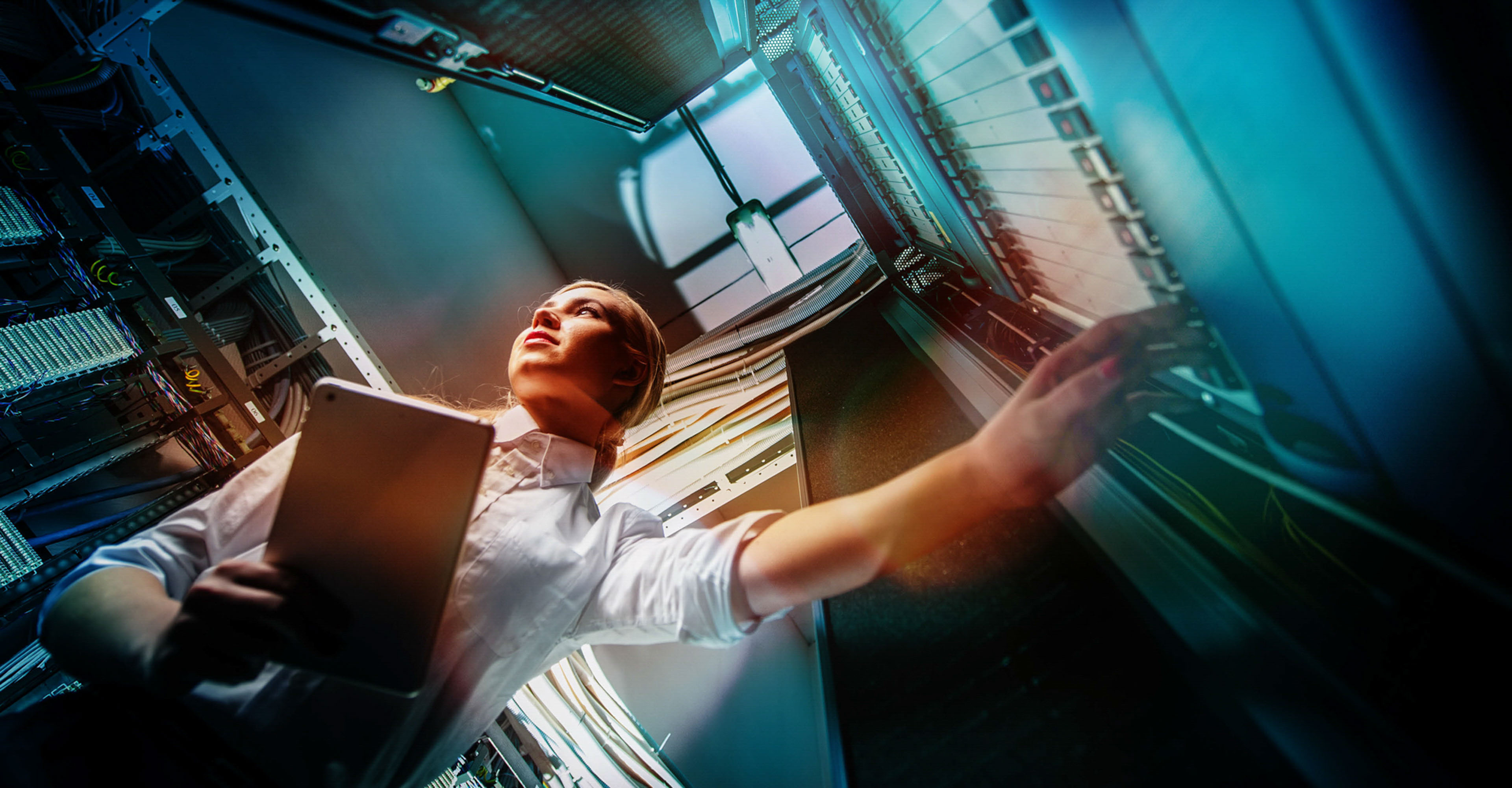 Young engineer businesswoman in network server room.