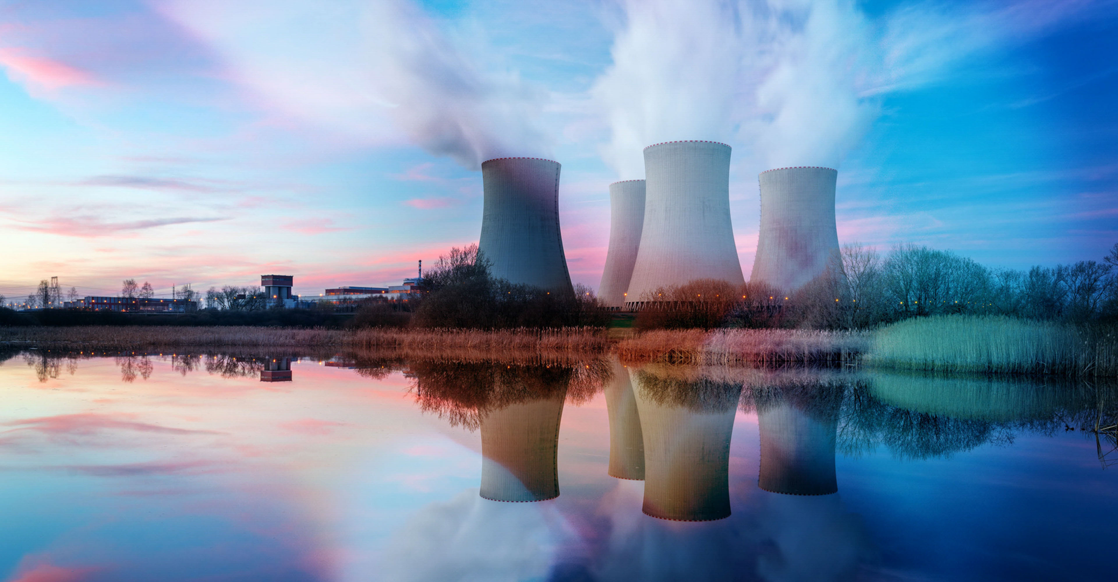 Nuclear power plant after sunset. Dusk landscape with big chimneys.
