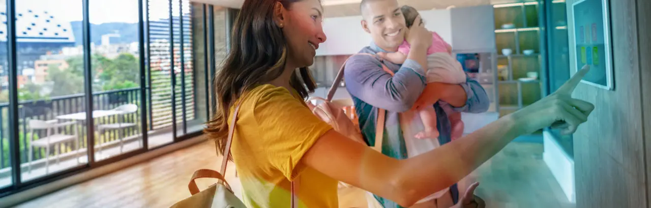 Happy family leaving the house locking the door using automated security system - smart home