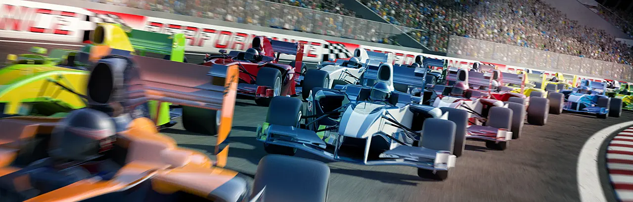 Racing cars speeding down around a bend in the track in front of a stadium filled with people.
