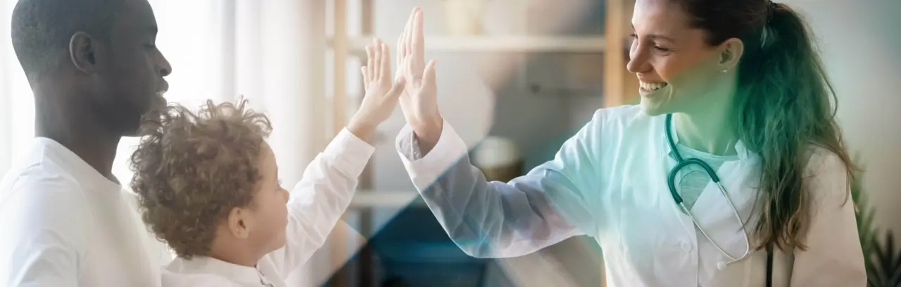 Happy  little child boy gives high five to female doctor pediatrician at medical  appointment