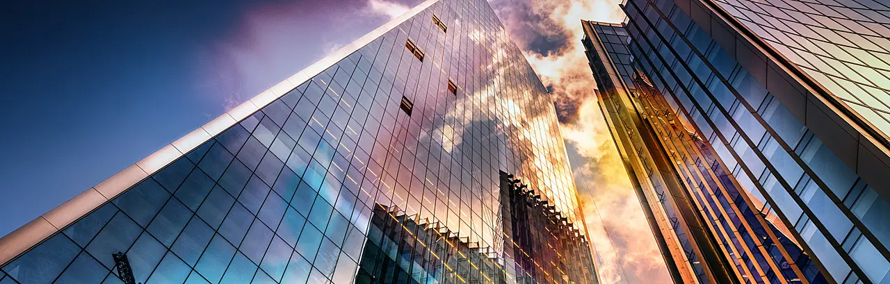 Bottom view of modern skyscrapers in business district in beautiful evening light at sunset