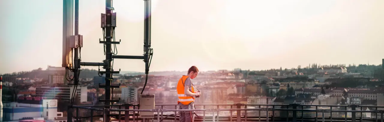 Telecommunication engineer repairing communication antenna on the top of chimney.