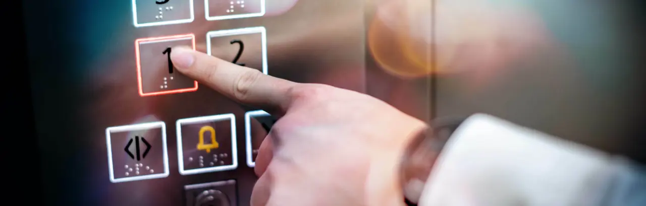 Male index finger pressing on the first floor button or floor number one in elevator (lift).