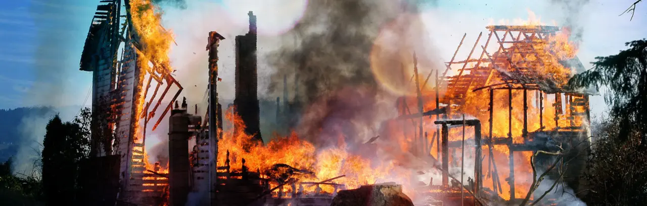 Old farm house completely consumed by fire is burnt to the ground.