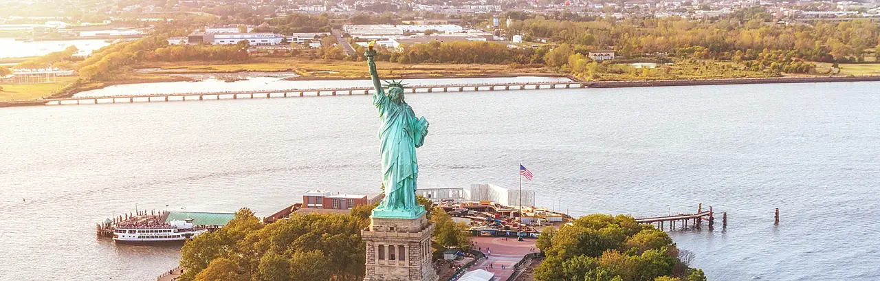 Aerial view of Statue of Liberty in Liberty Island and sunset. New York, USA