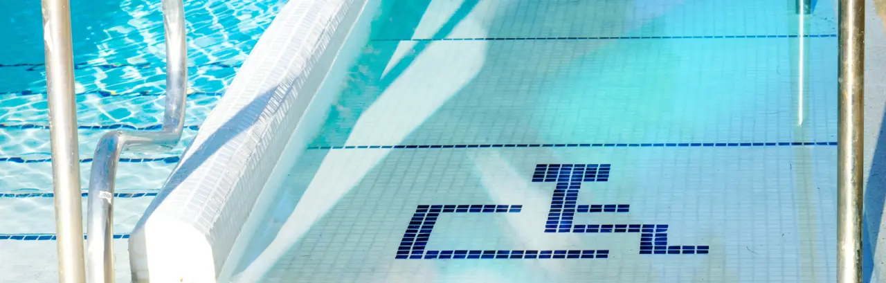 Handicap accessible ramp into a swimming pool marked with the handicapped symbol