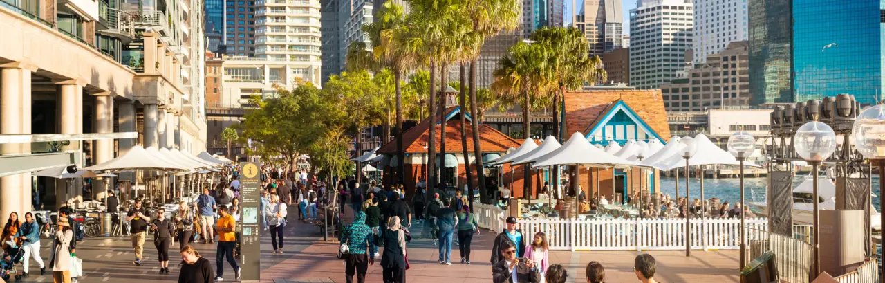a group of people walking on a boardwalk in Sydney circular Quay