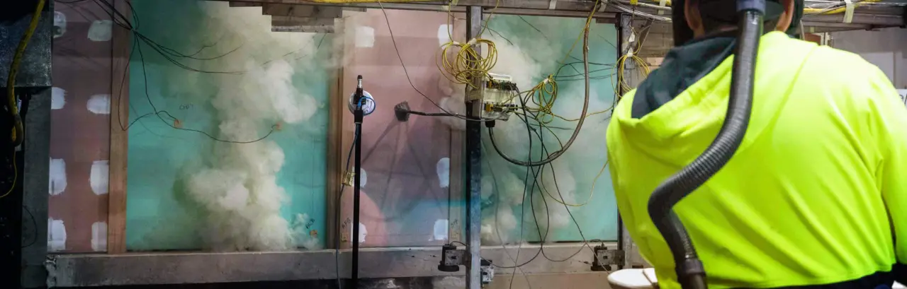 Fire testing being conducted in a laboratory with smoke coming up from multiple sources