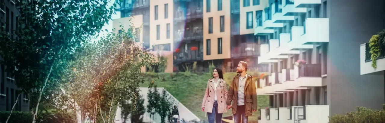 Young couple looking for apartment. Image taken at average residential area with multiple buildings.