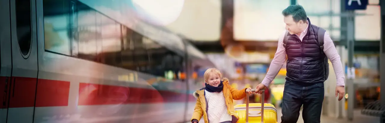 Smiling little boy and his father waiting express train on railway station platform.