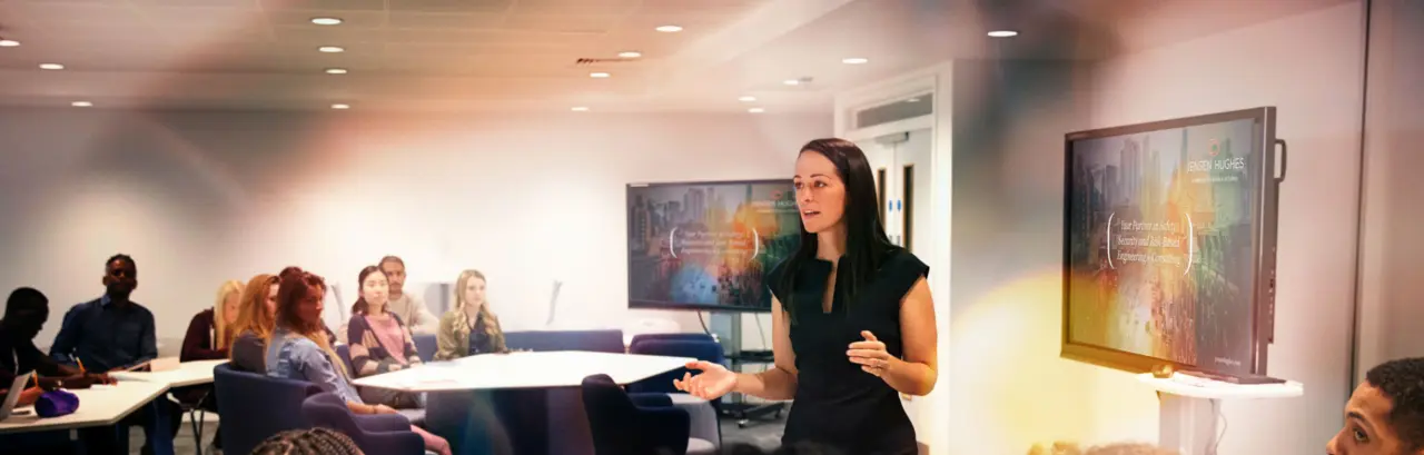 Female teacher addressing students in a classroom.