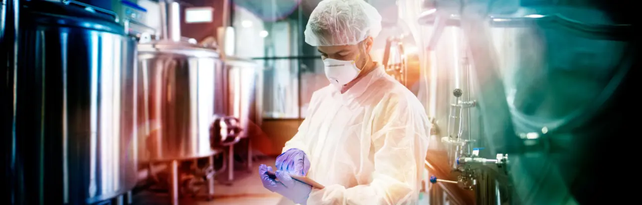 Professional technologist using tablet in production plant checking productivity and quality.