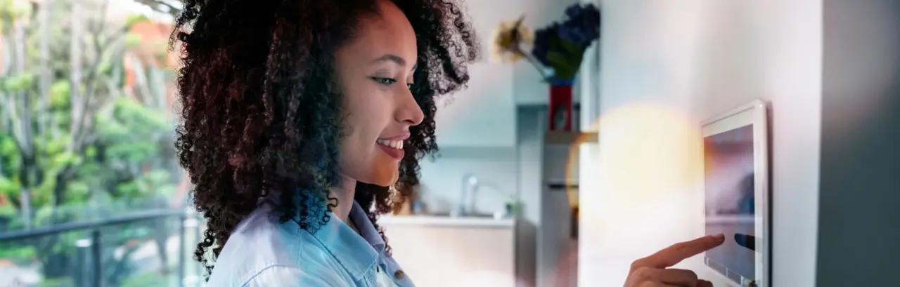 woman setting up the intelligent home system on a tablet computer - technology concepts