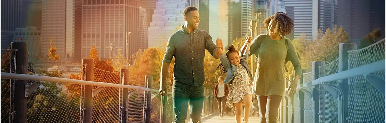 Young family with daughter taking a walk on footbridge