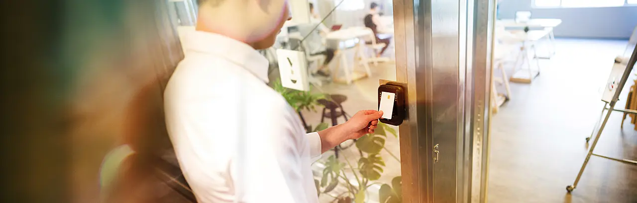 Man using his security badge to gain access to a room