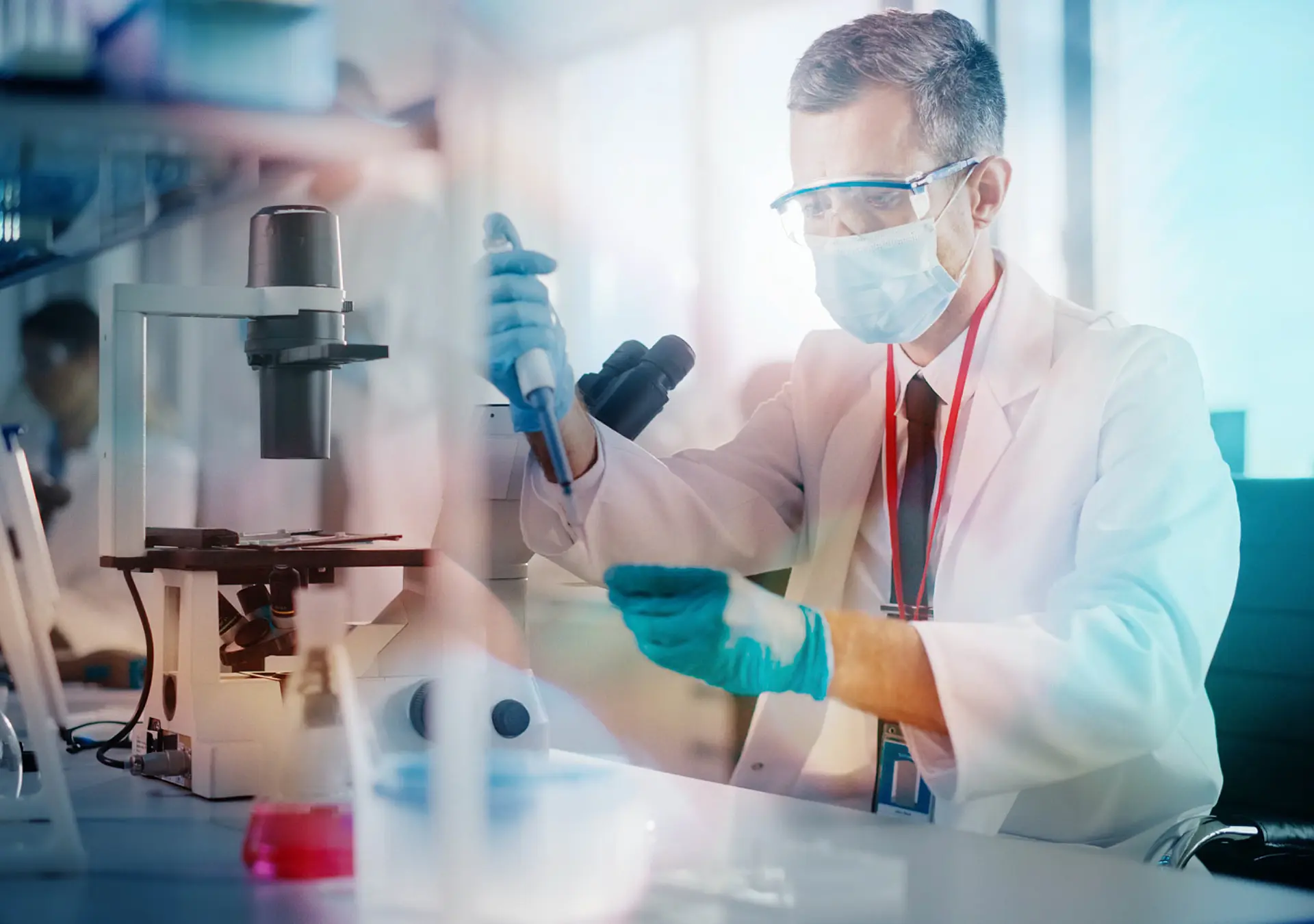 Scientist Wearing Face Mask Uses Micro Pipette Dropper to Mix Petri Dish Sample