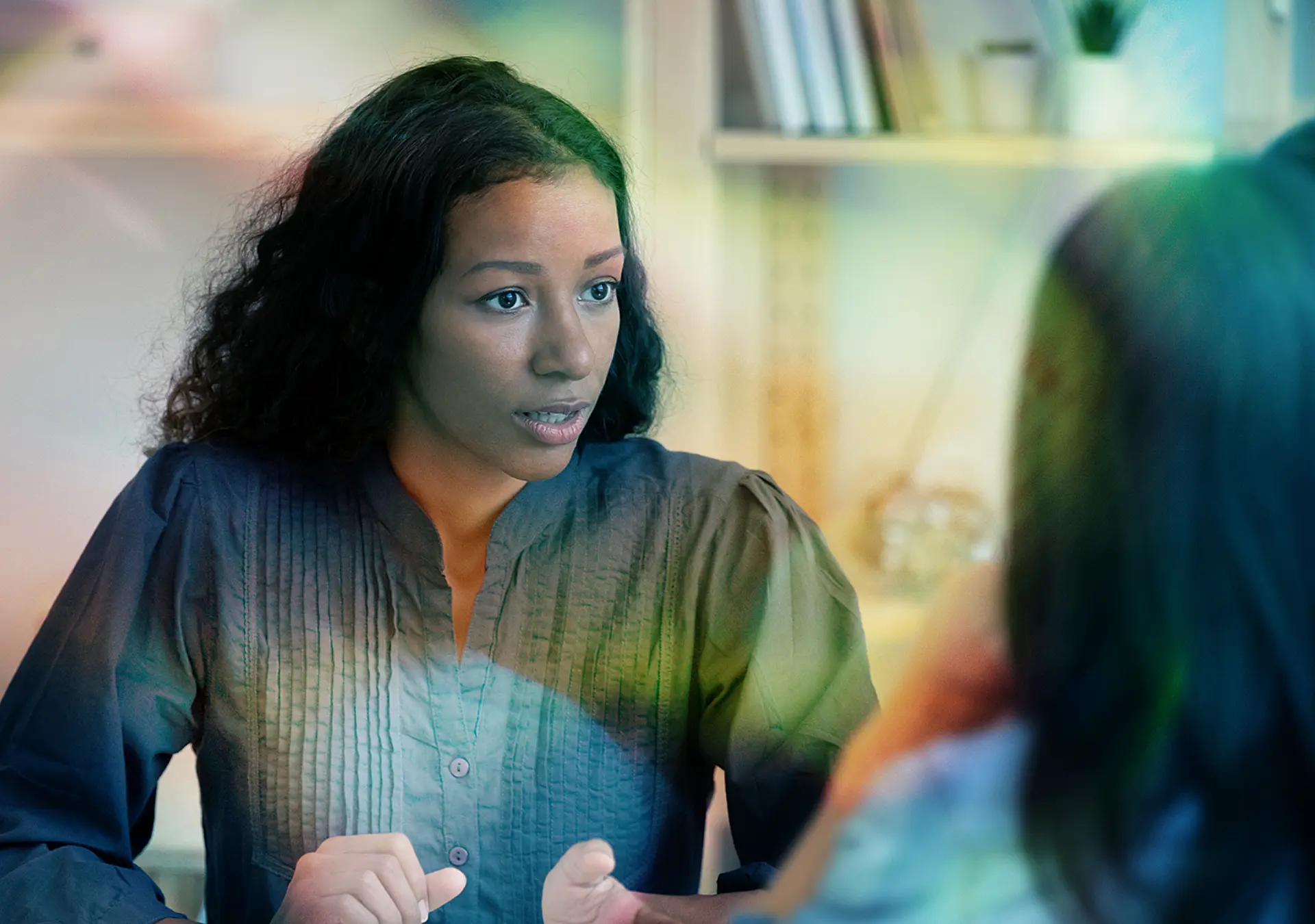Focused African American female real estate agent or architect talk with young couple at meeting