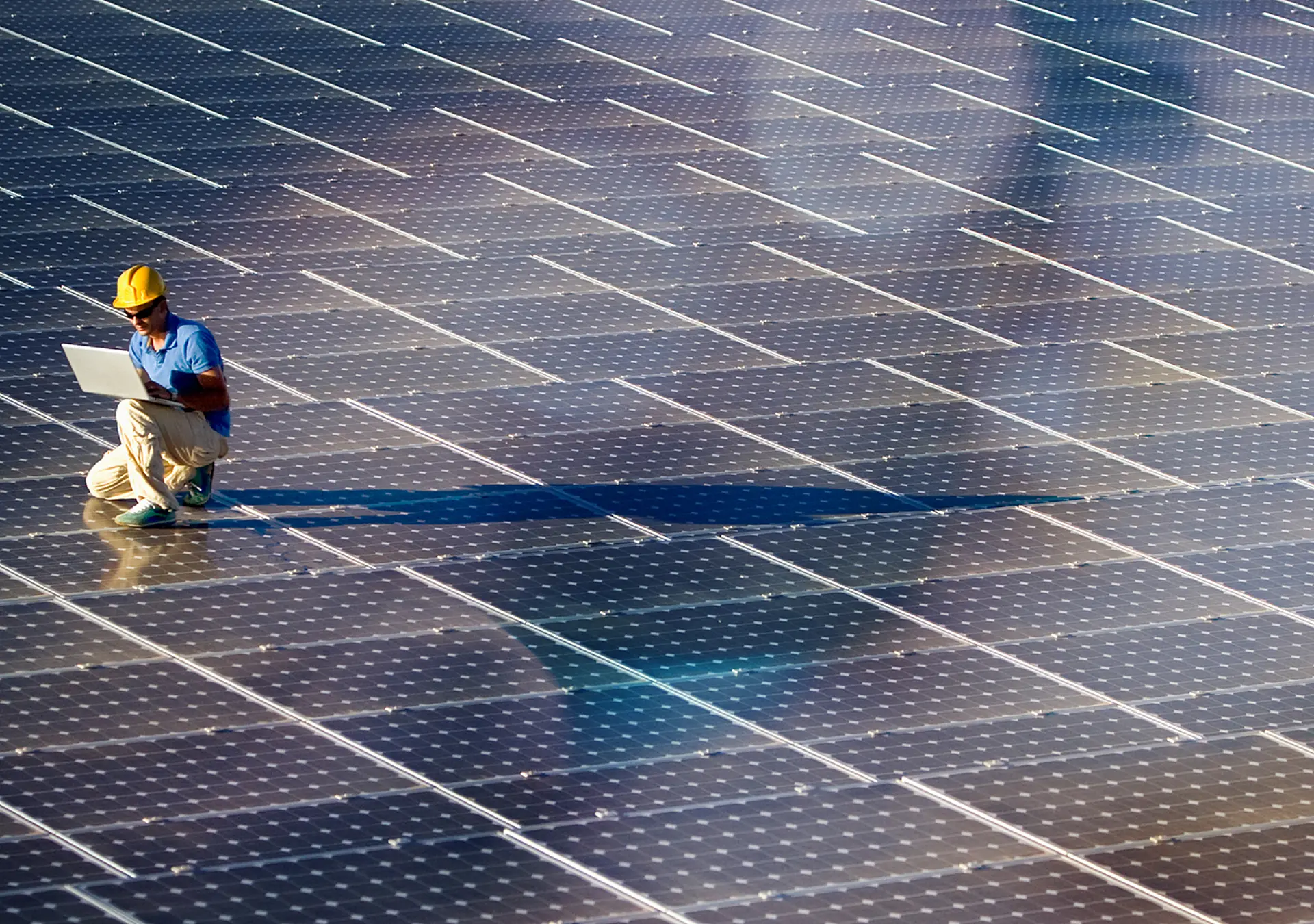 Image of a engineer with a laptop at a photovoltaic farm.