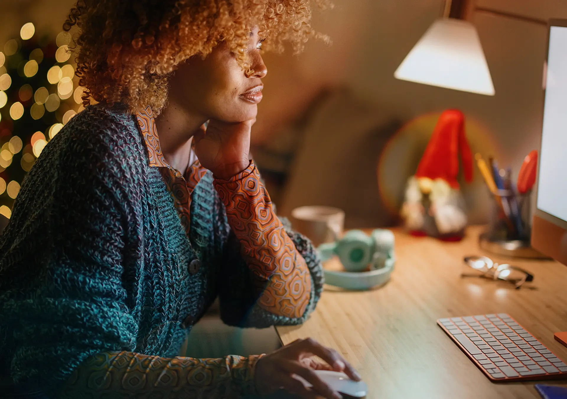 Middle aged woman buying online Christmas presents from her cozy home late at night.