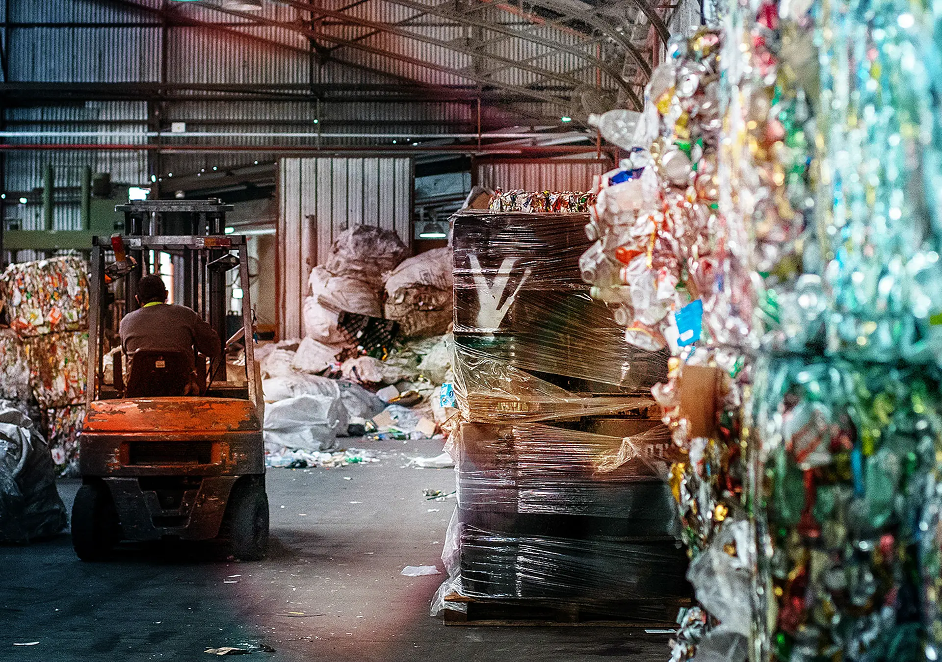 Interior of solid waste processing facility full of blocks and bags of recycling materials