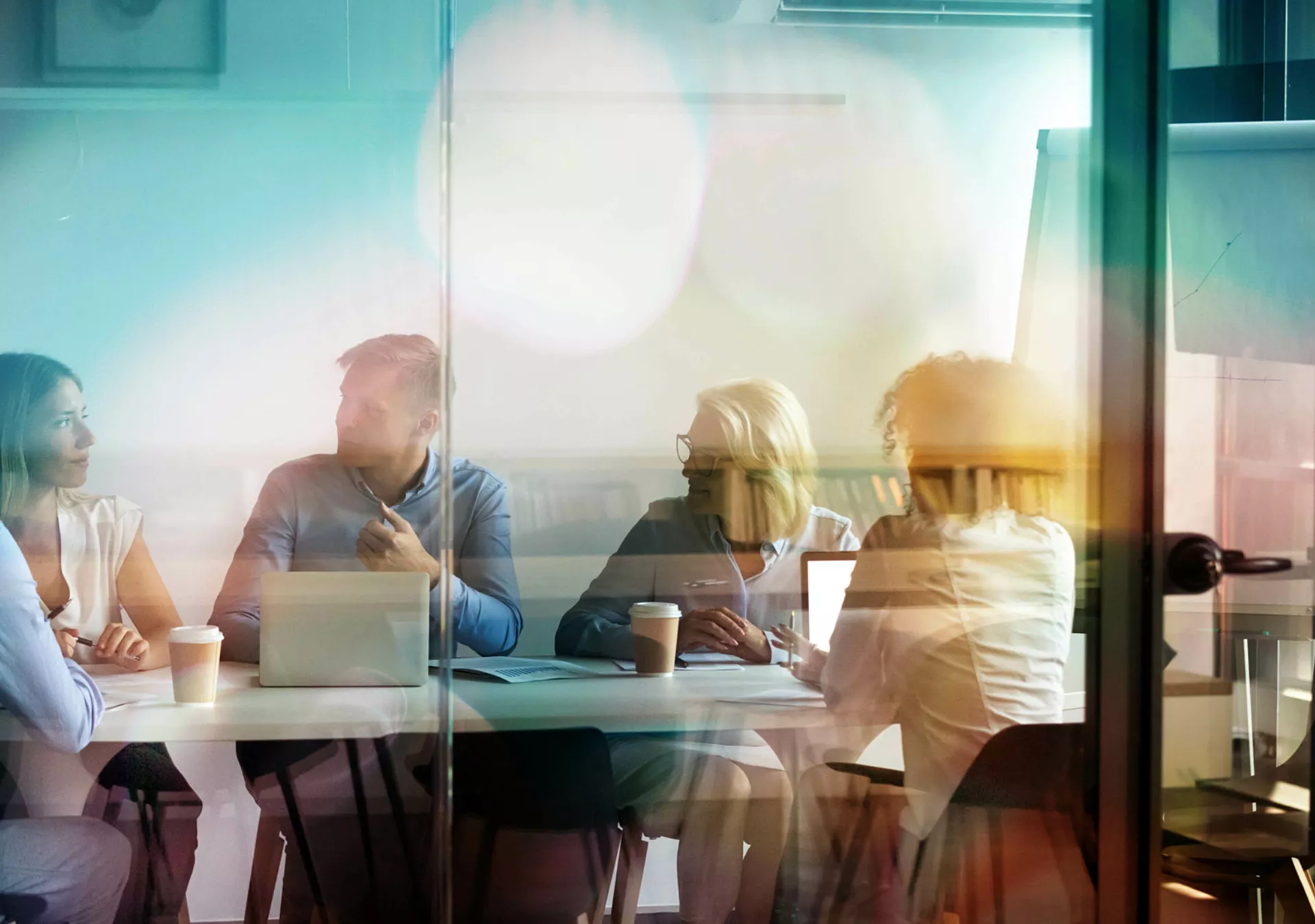 Buisness meeting taking place behind closed doors with five employees in attendence