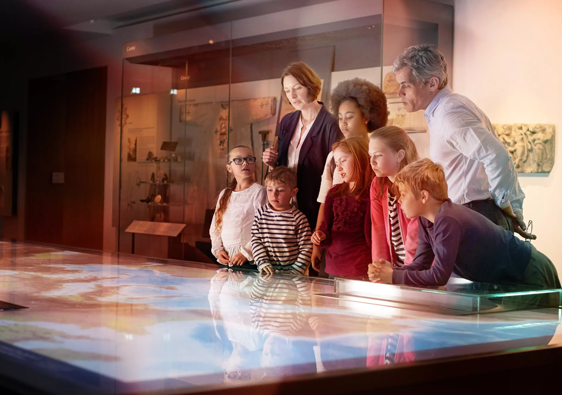 Pupils On School Field Trip To Museum Looking At Map