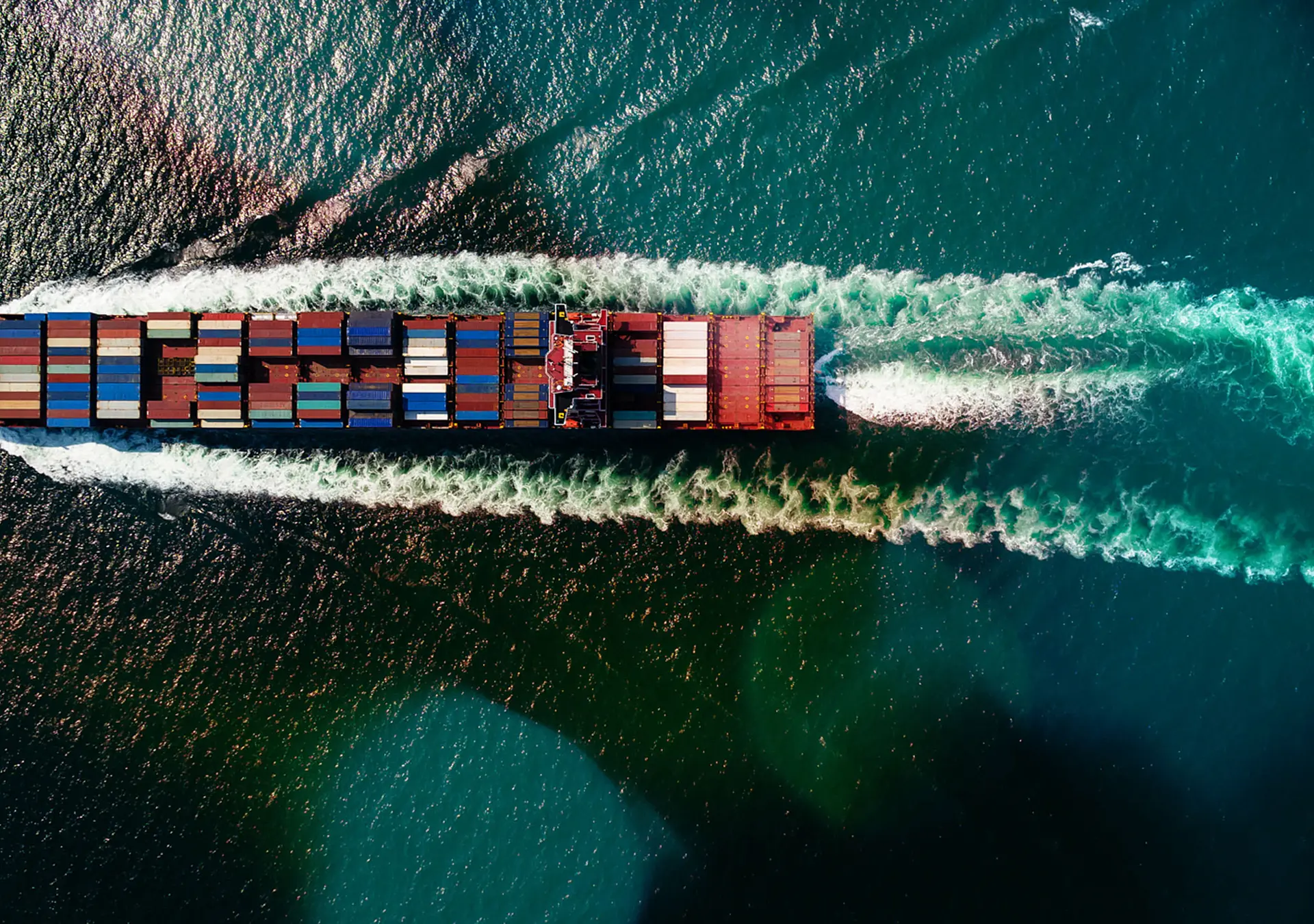 Cargo container ship sailing full speed in sea to import export goods and distributing products