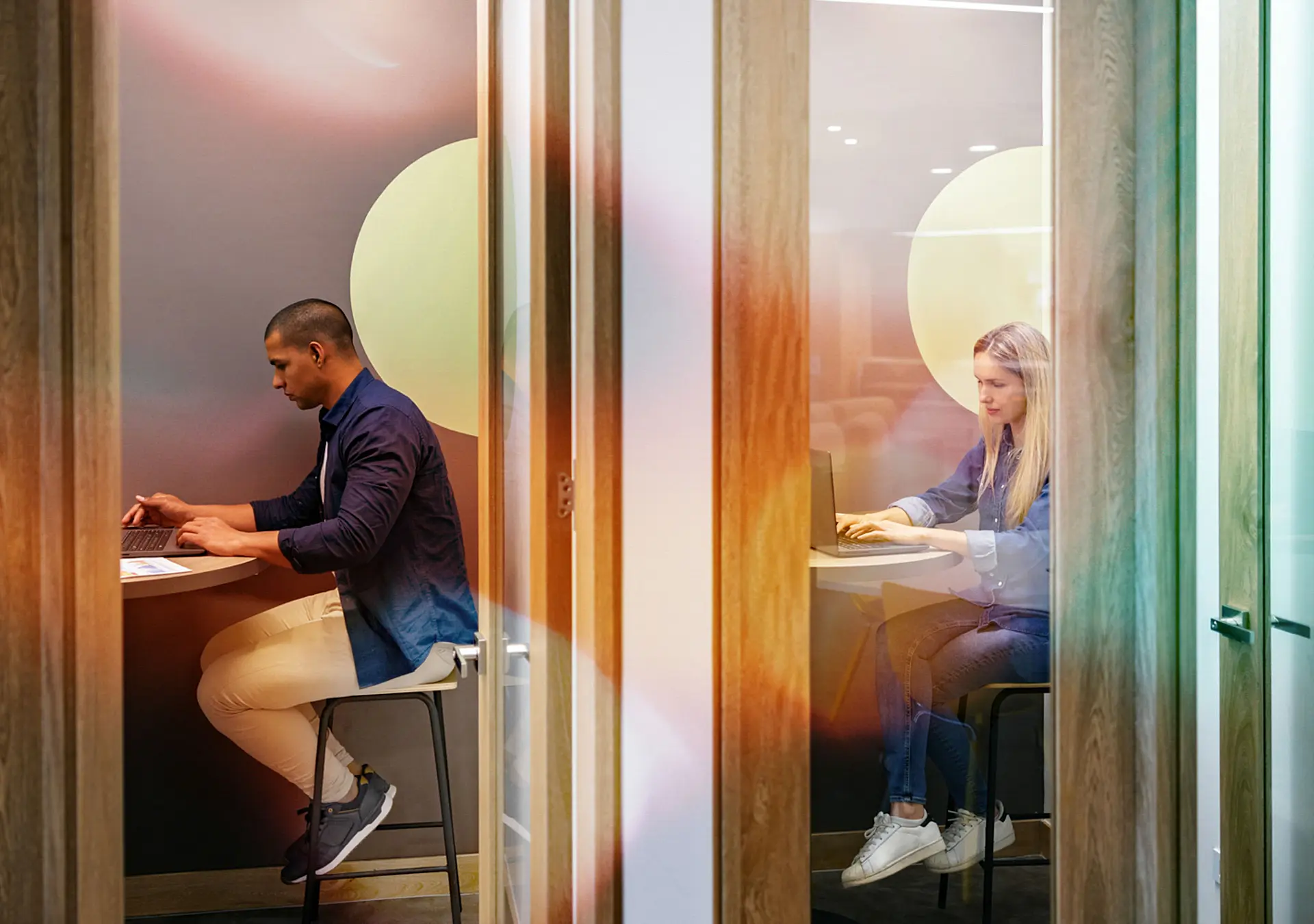 Business people working in private cubicles at a coworking office