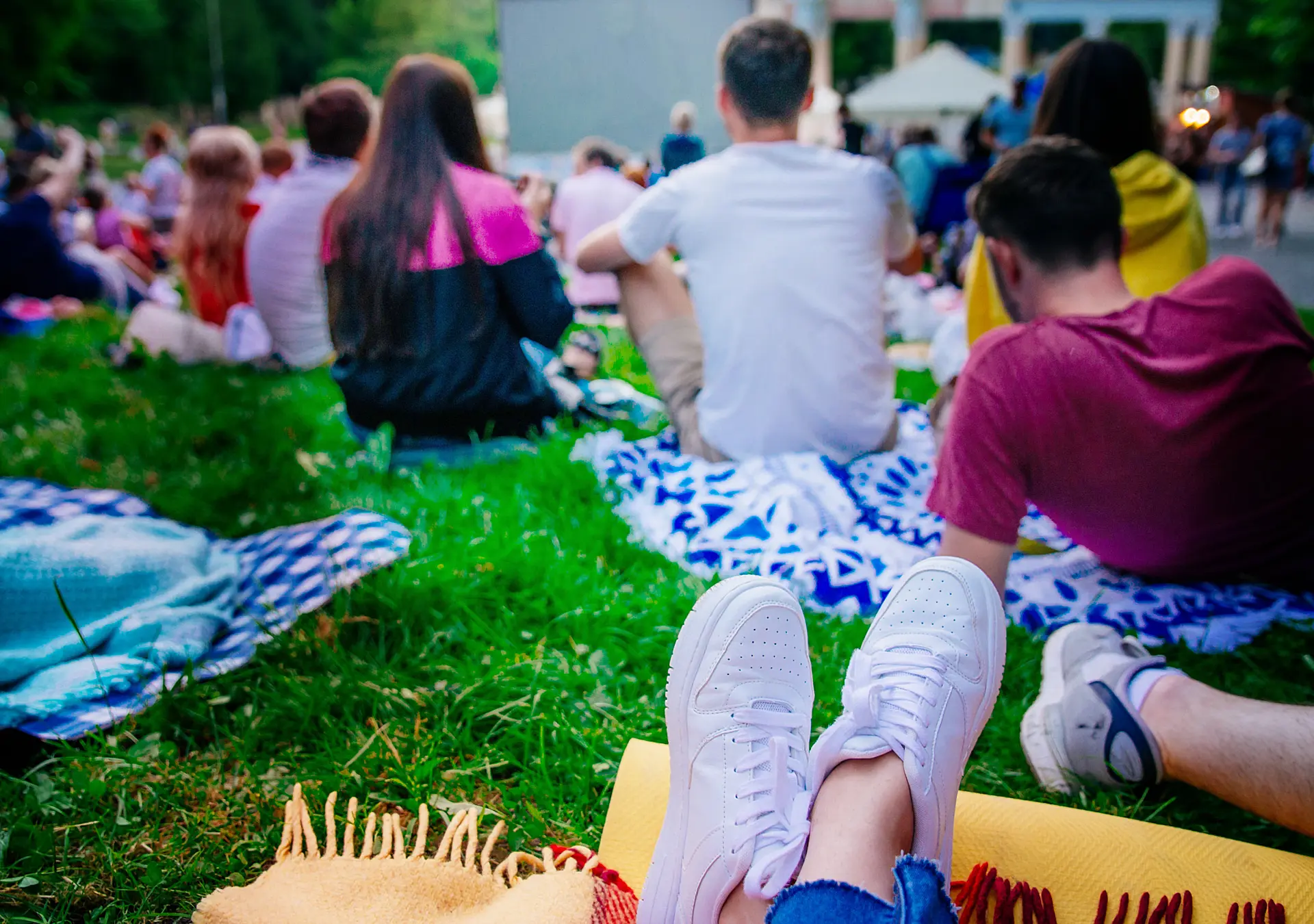 People watching movie in open air cinema in city park