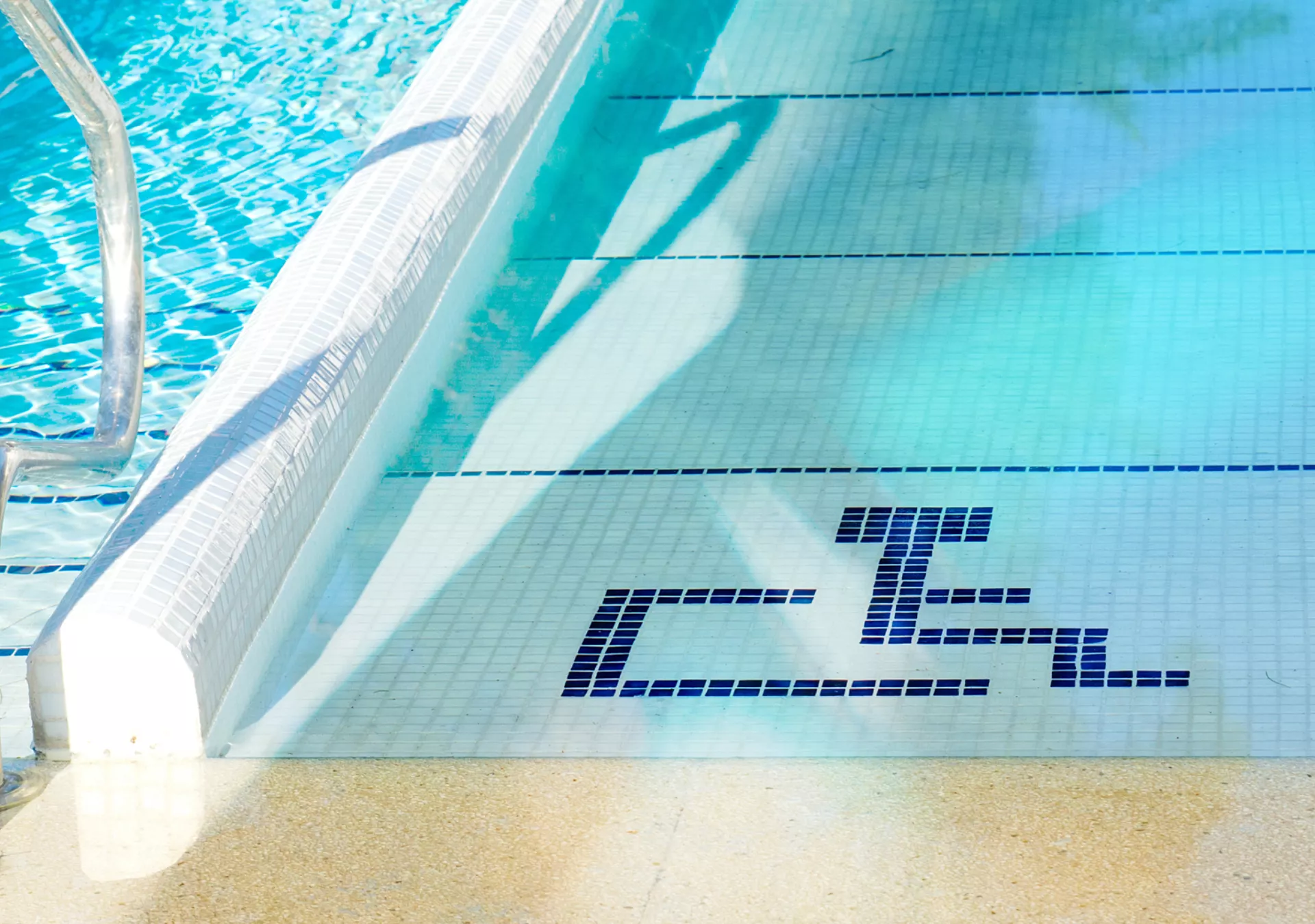 Handicap accessible ramp into a swimming pool marked with the handicapped symbol