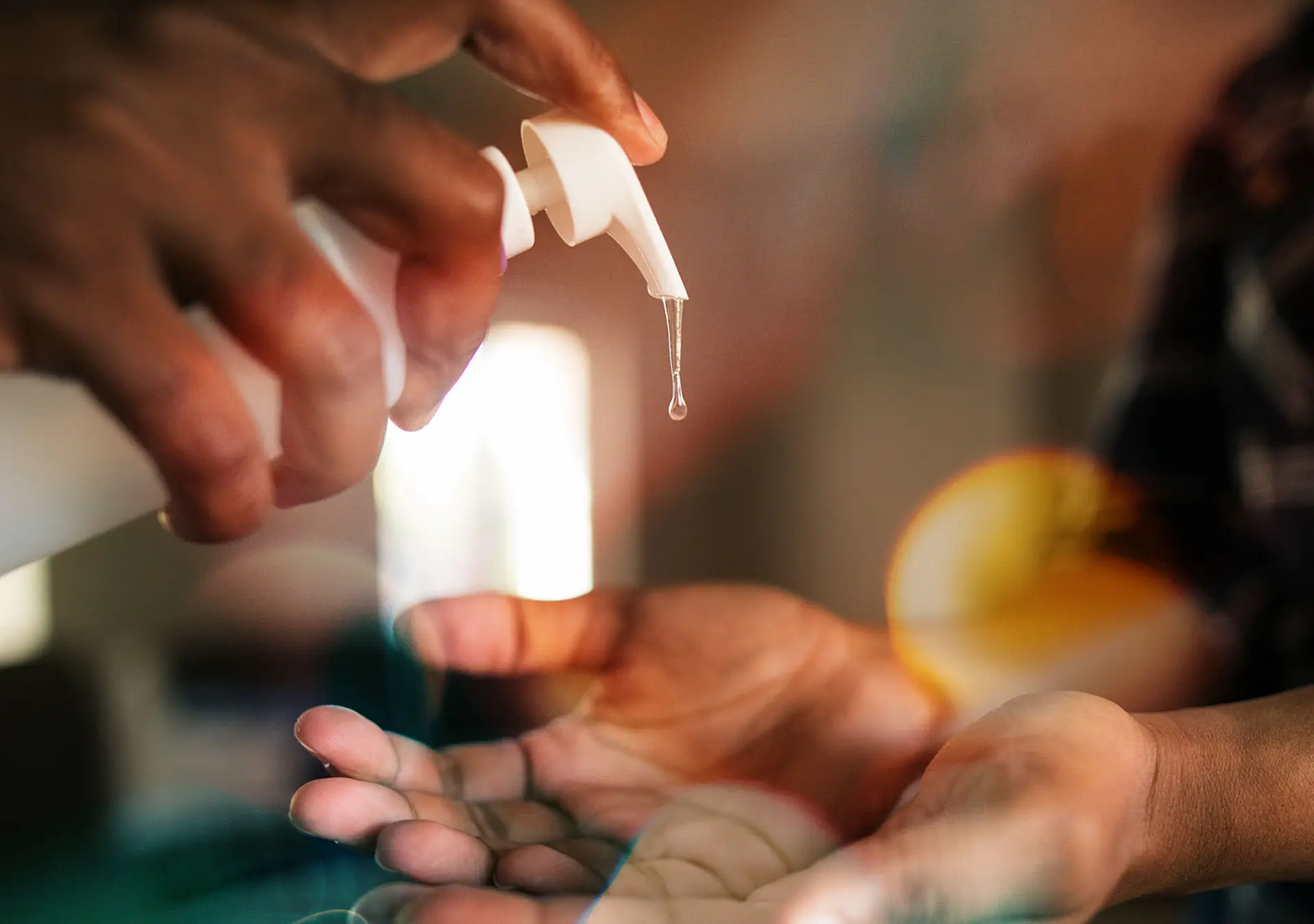 Man pumping out hand sanitizer into woman's hands