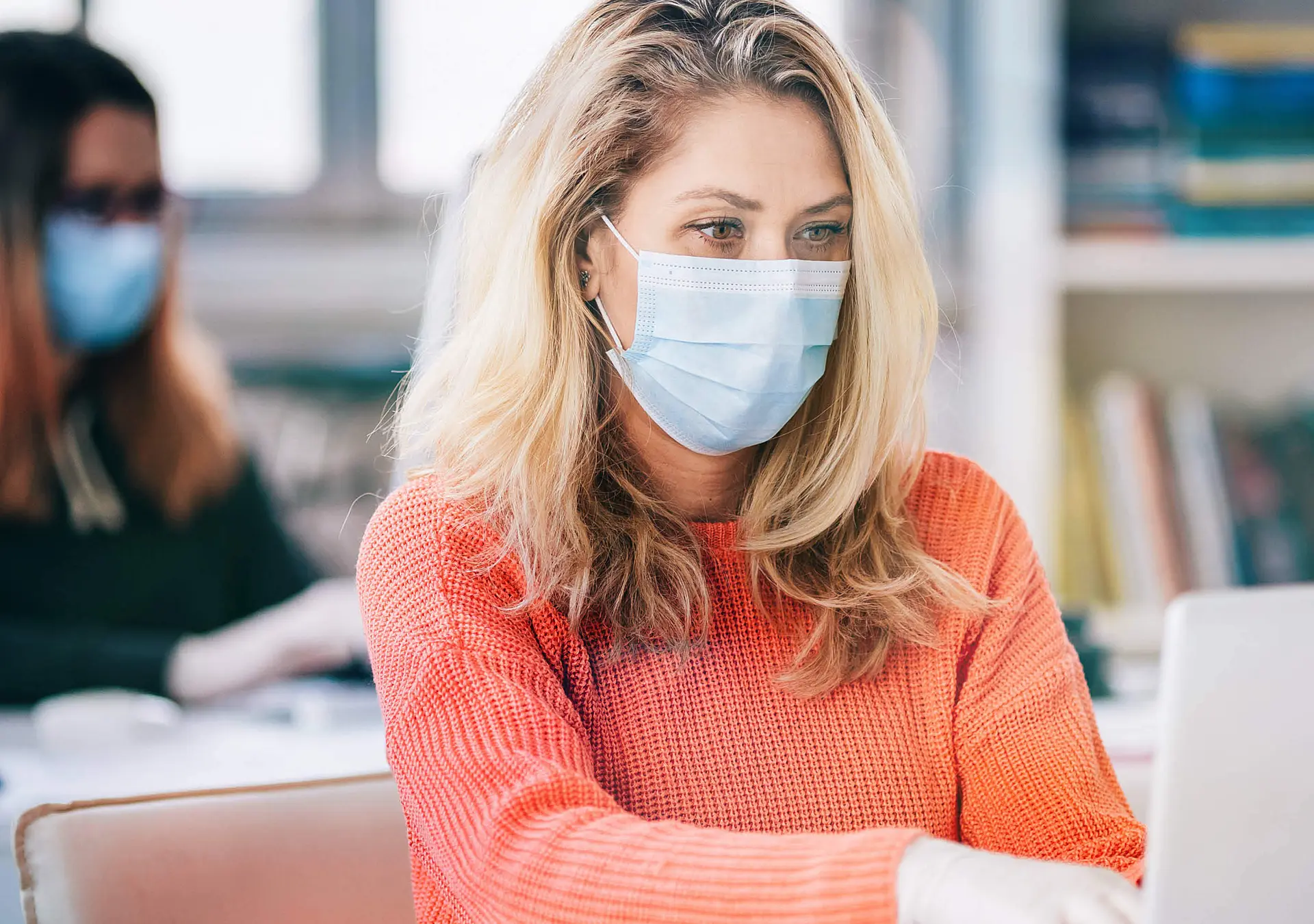 Colleagues in the office working while wearing medical face mask during COVID-19