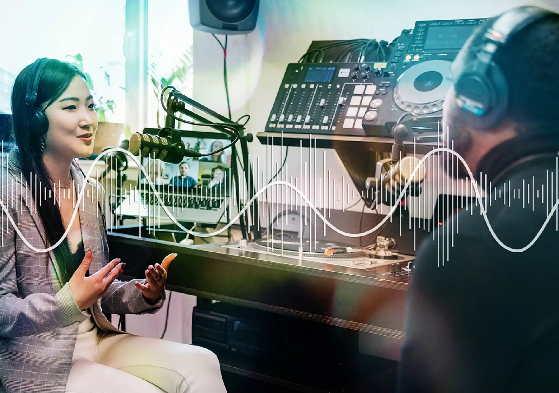 Young woman and mid adult man recording a podcast in their studio.