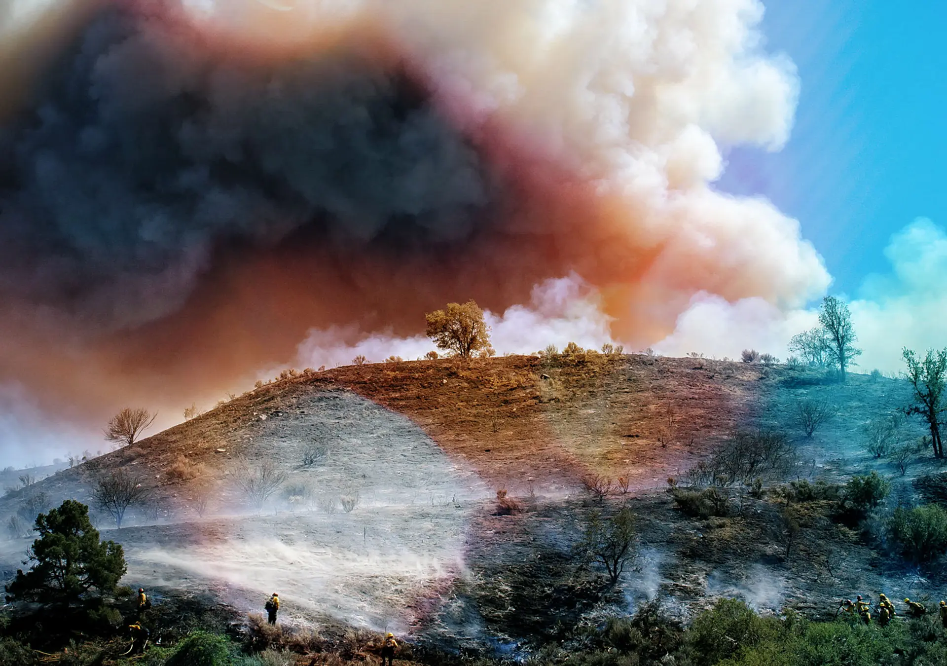 Small group of firefighters battling out of control wildfire on hilltop north of Los Angeles.
