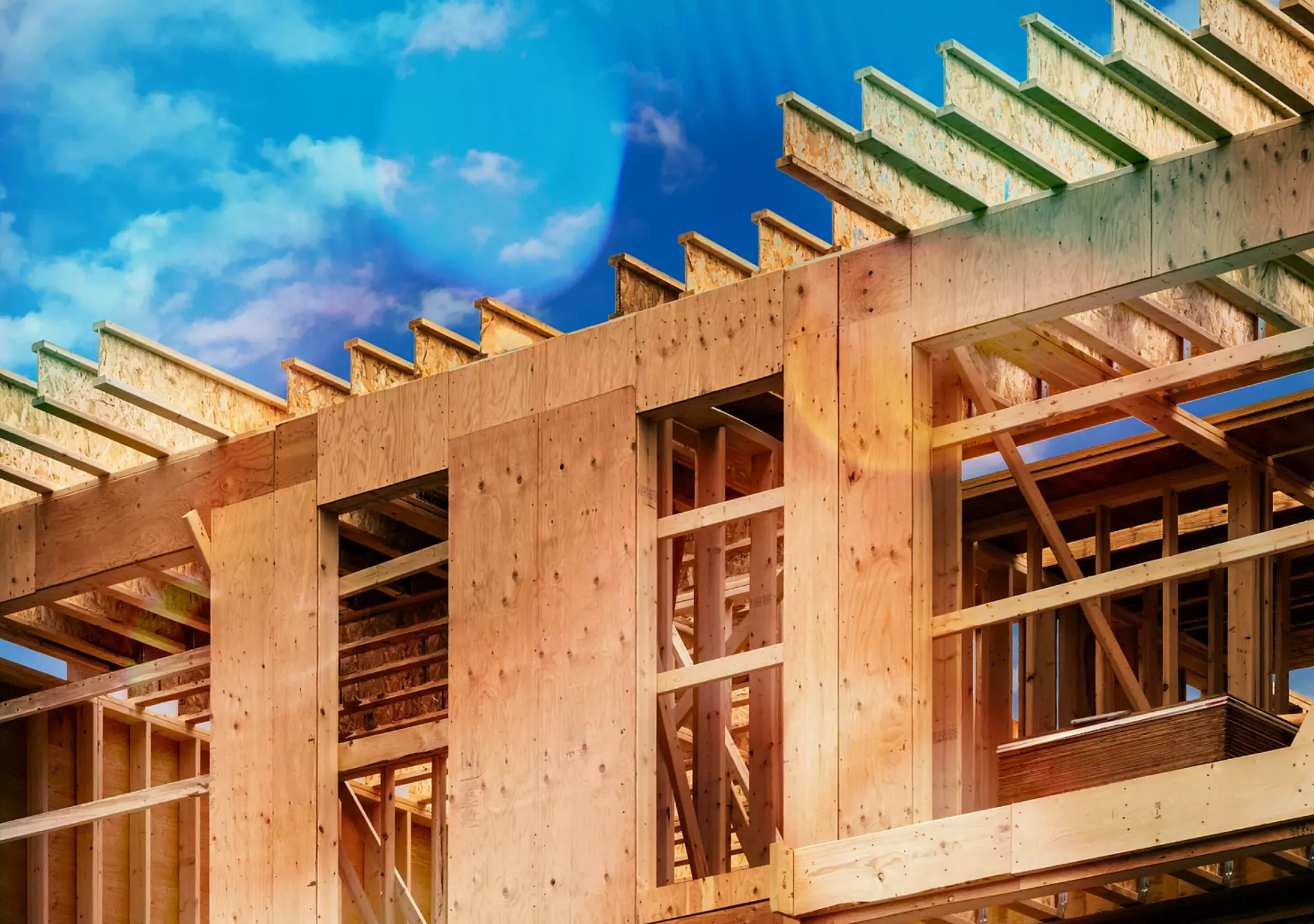 Plywood sheathing and engineered wood joists/rafters forming the roof of a house under construction