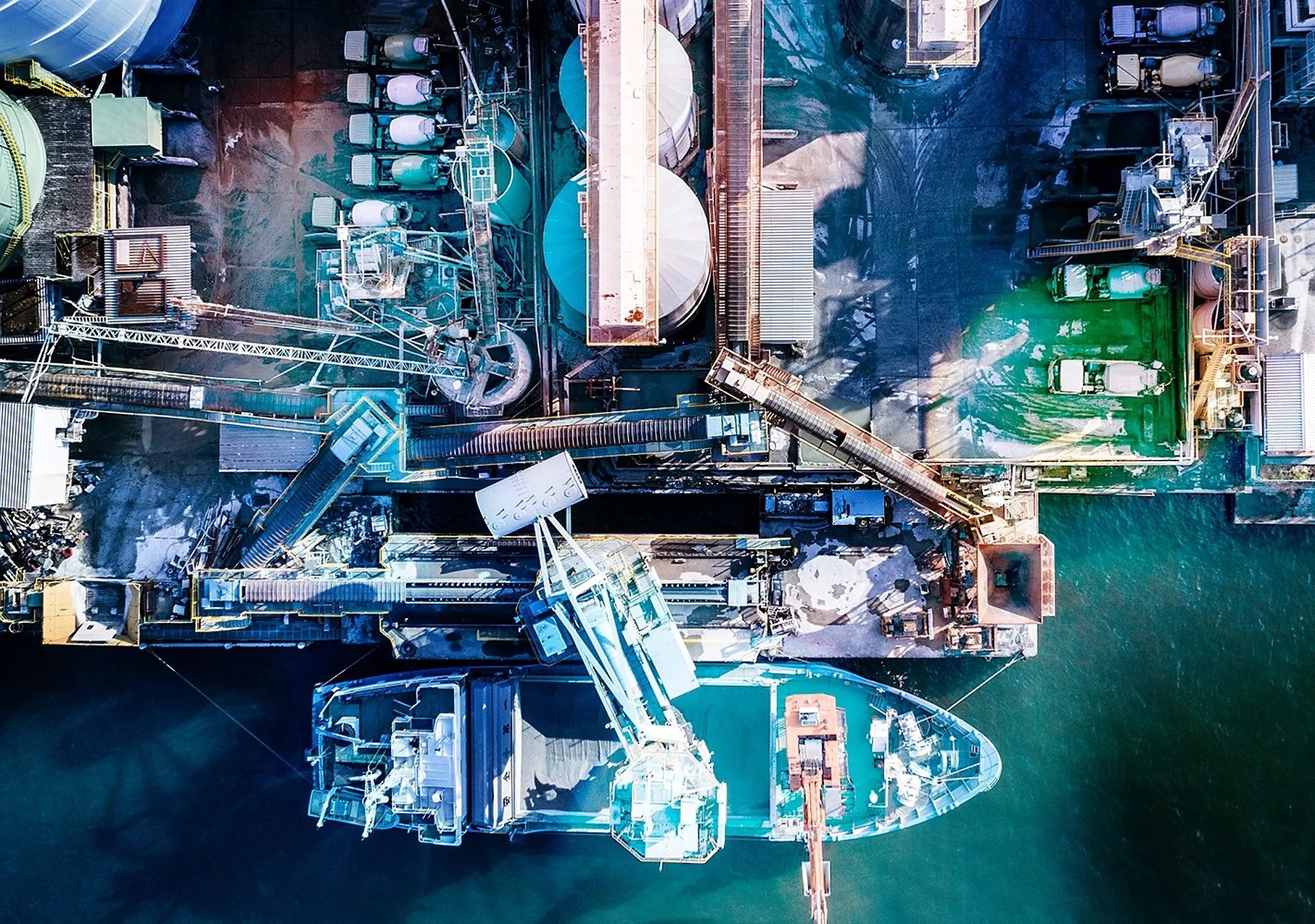 Oil refinery storage units with tanker ships stock photo. Aerial view from directly above.