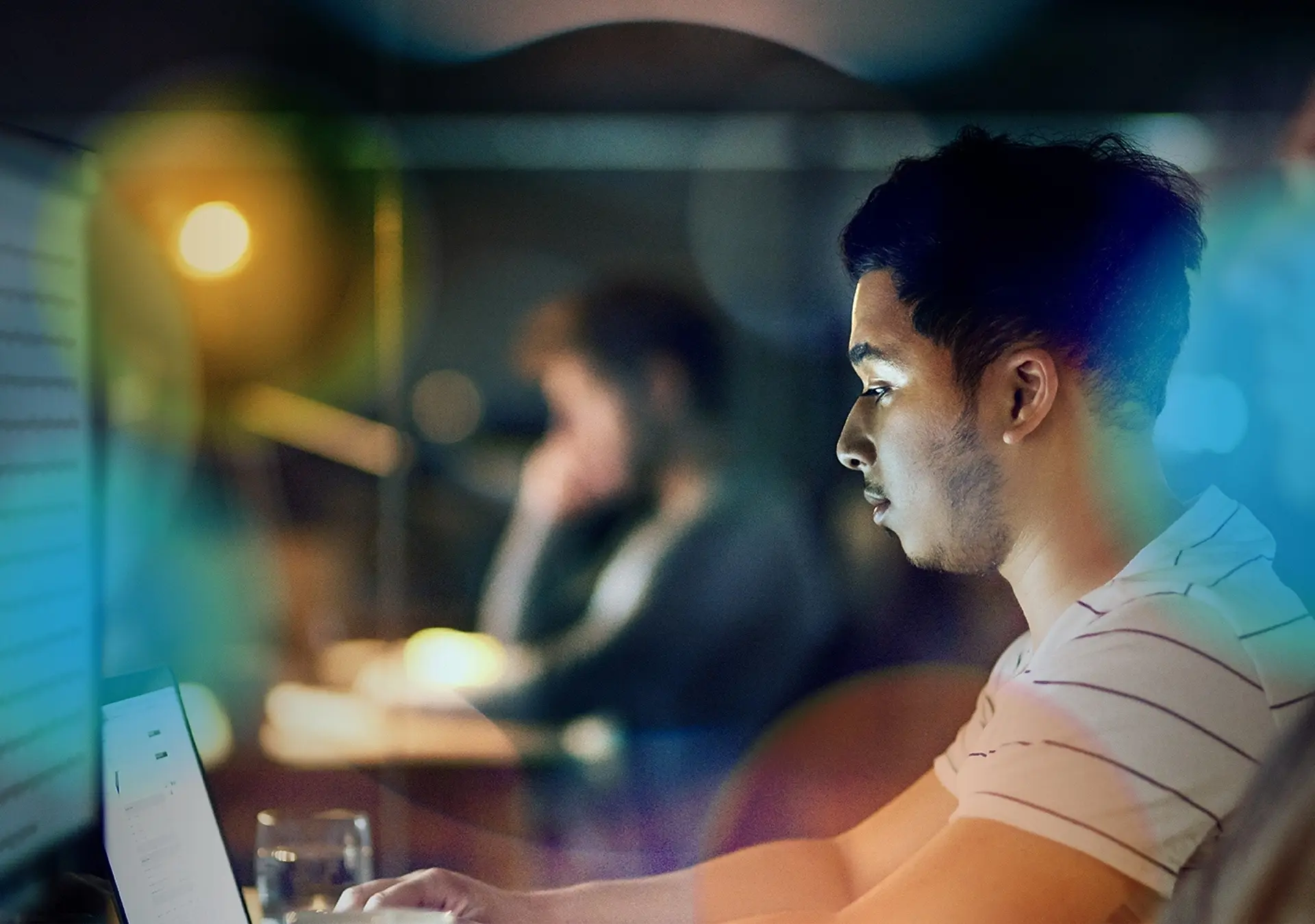 Shot of a young designer working late on a laptop and computer in an office