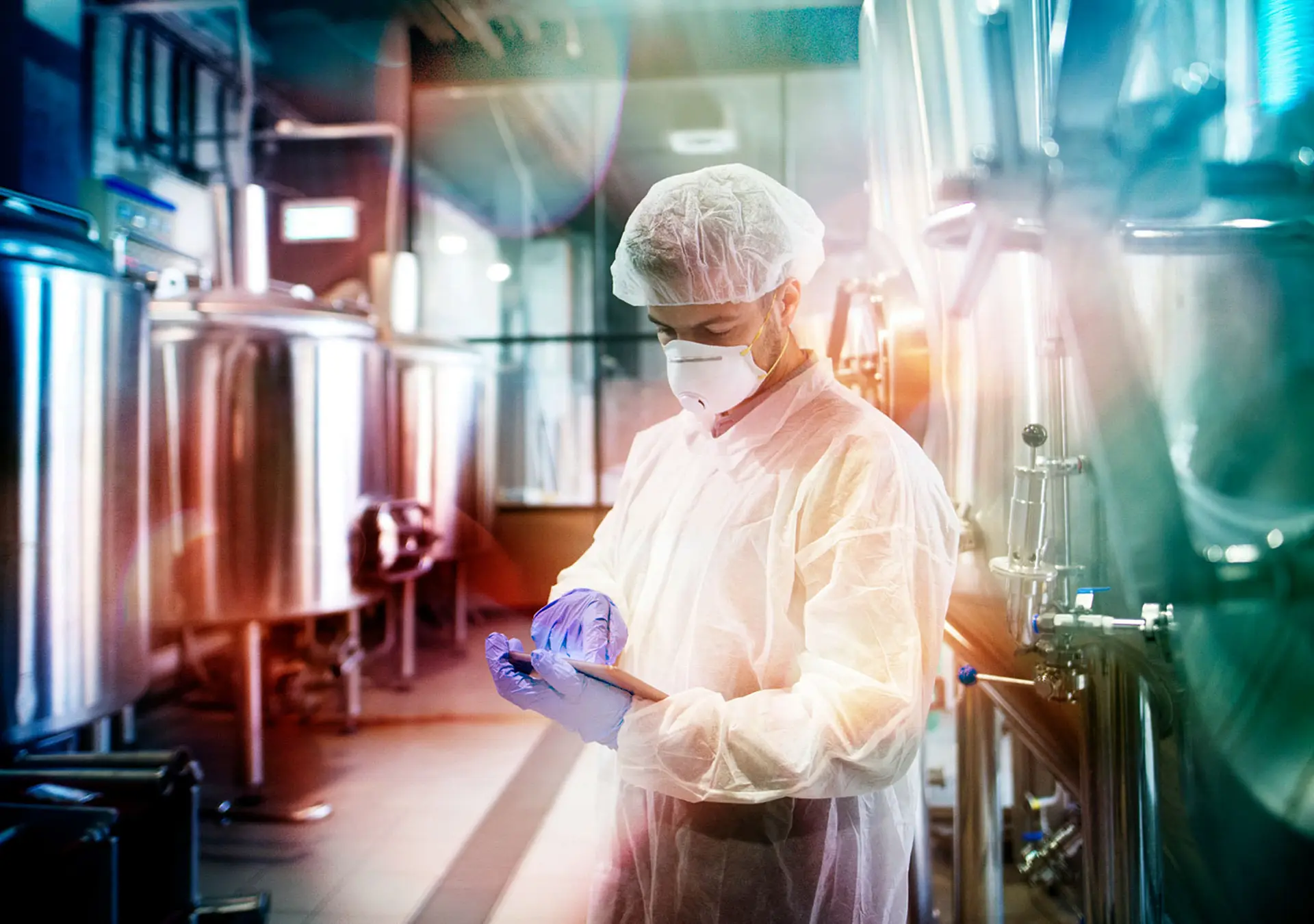 Professional technologist using tablet in production plant checking productivity and quality.