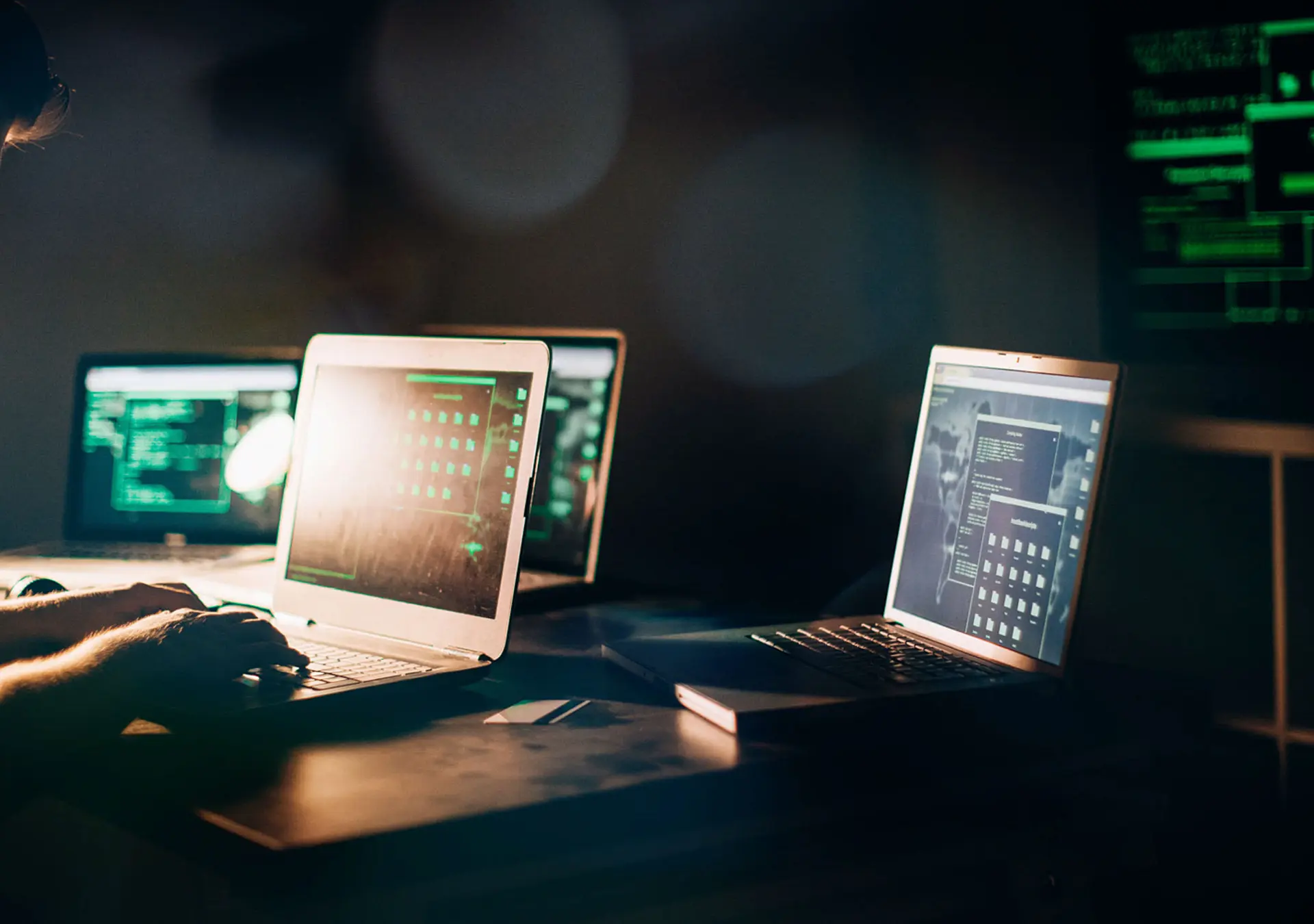 One hacker sitting in the dark room in front of his computers, hacking some internet data.
