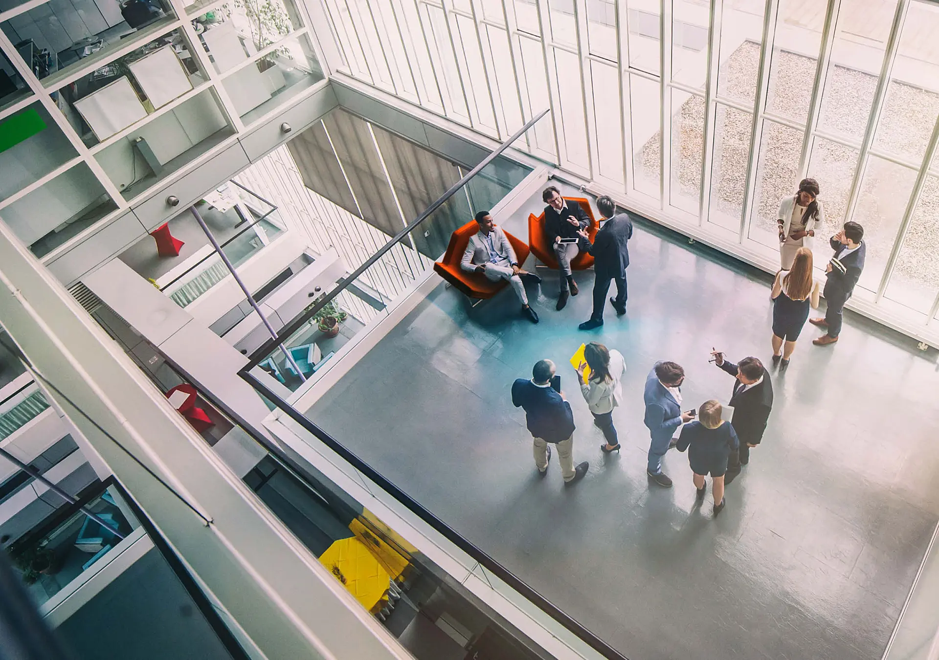 A high-angle view of a mixed age group of eleven business persons standing in the office building