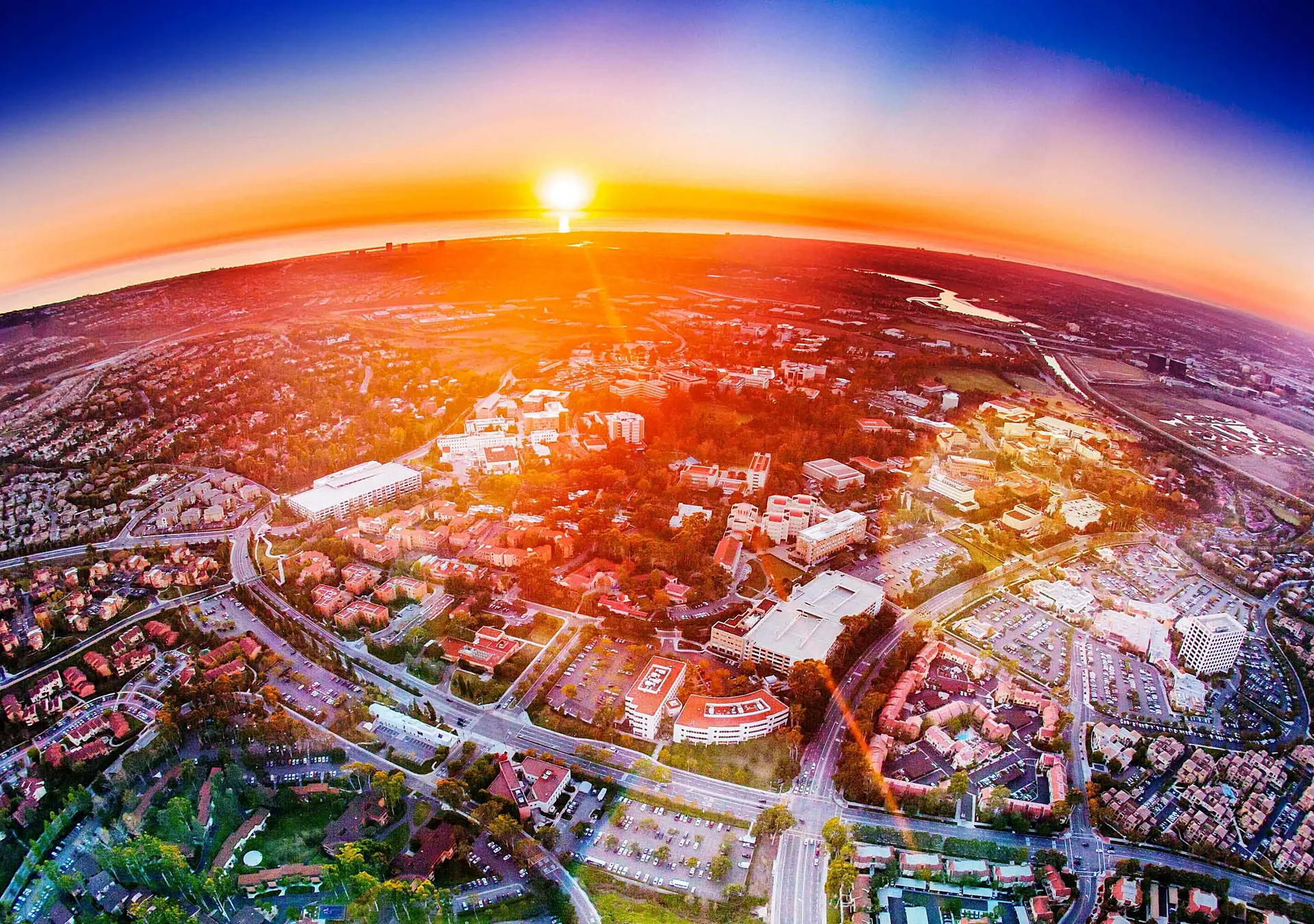 An aerial view of homes and the California coast at sunset