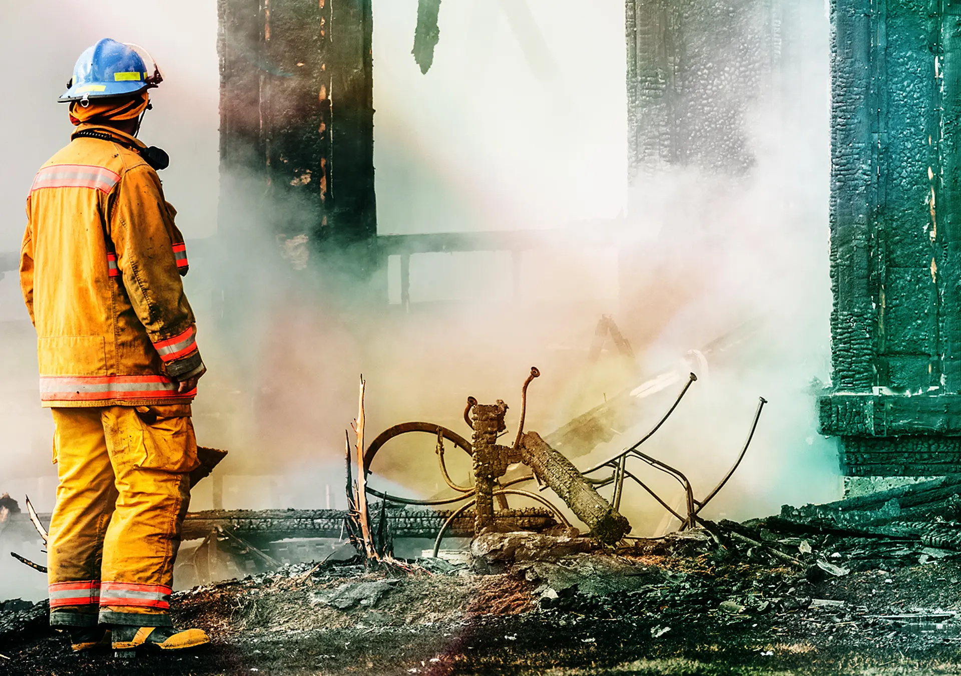 A firefighter investigates the devastation of a house fire.