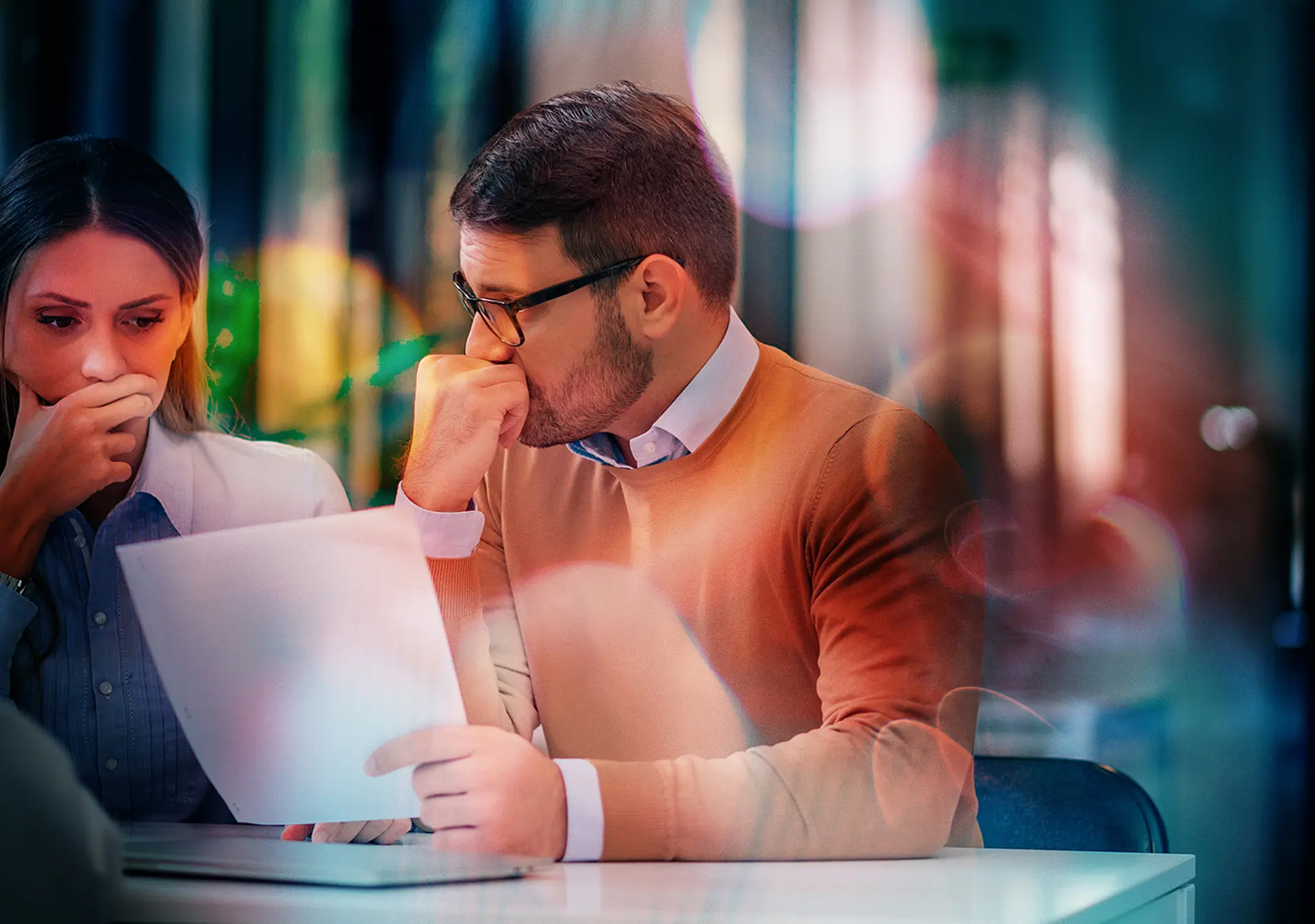 Portrait of a couple with financial problems looking at document in financial adviser's office.